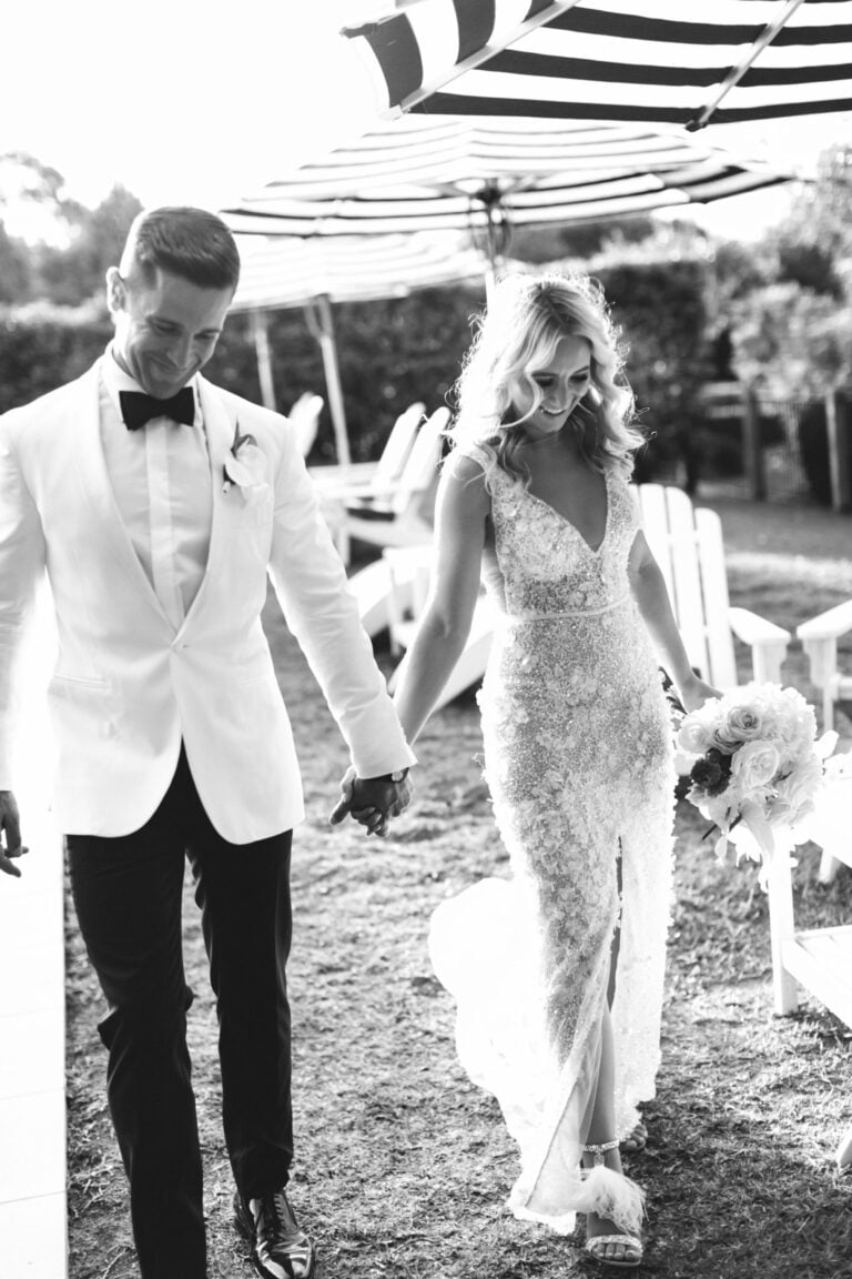 beautiful couple holding hands after wedding - black and white photo