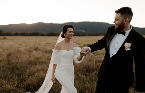 groom tagging gently the bride in a grassy field