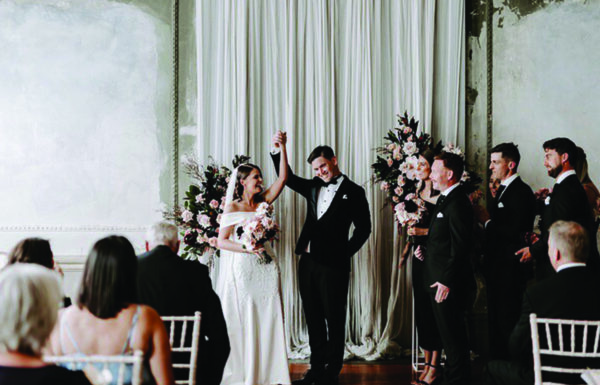 bride and groom raised their hands after their successful wedding ceremony