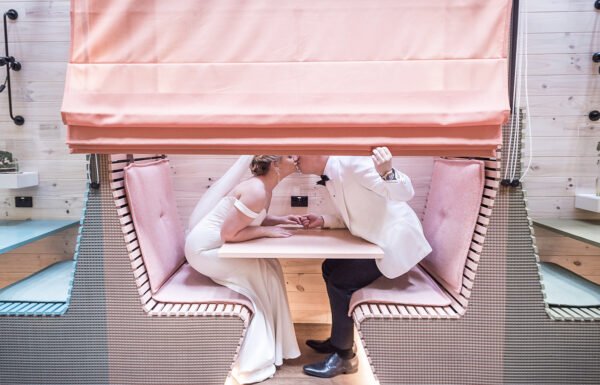 bride and groom kissing in a cafe for a photoshoot
