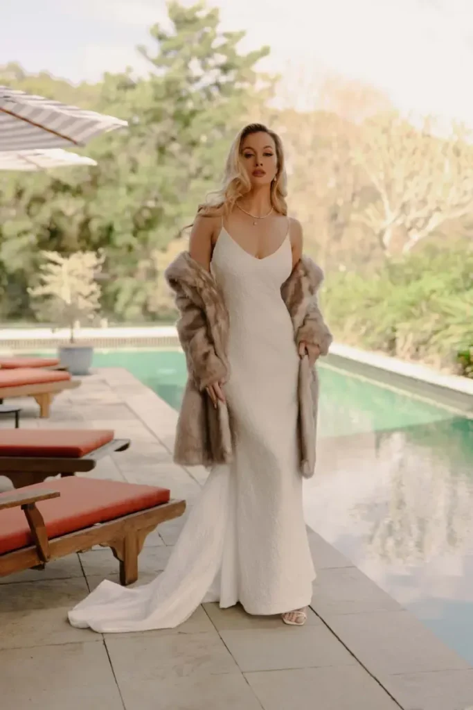 A bride wearing a backless wedding dress, shown from the front