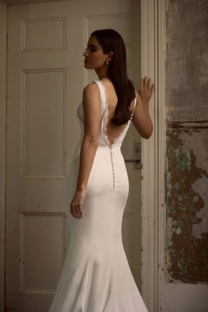 a backless wedding gown by anna campbell with lace trim