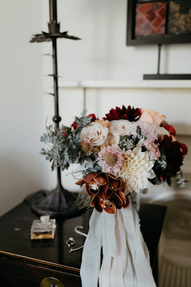 a bouquet of red and white flowers arranged beautifully on a table, adding color and charm to the wedding day