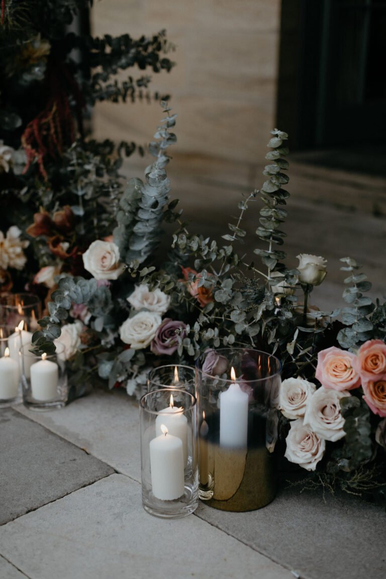 a beautiful arrangement of flowers and candles placed neatly on the floor, creating a warm and inviting atmosphere