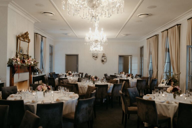 1. A beautifully decorated wedding reception room featuring a sparkling chandelier and elegantly set tables.