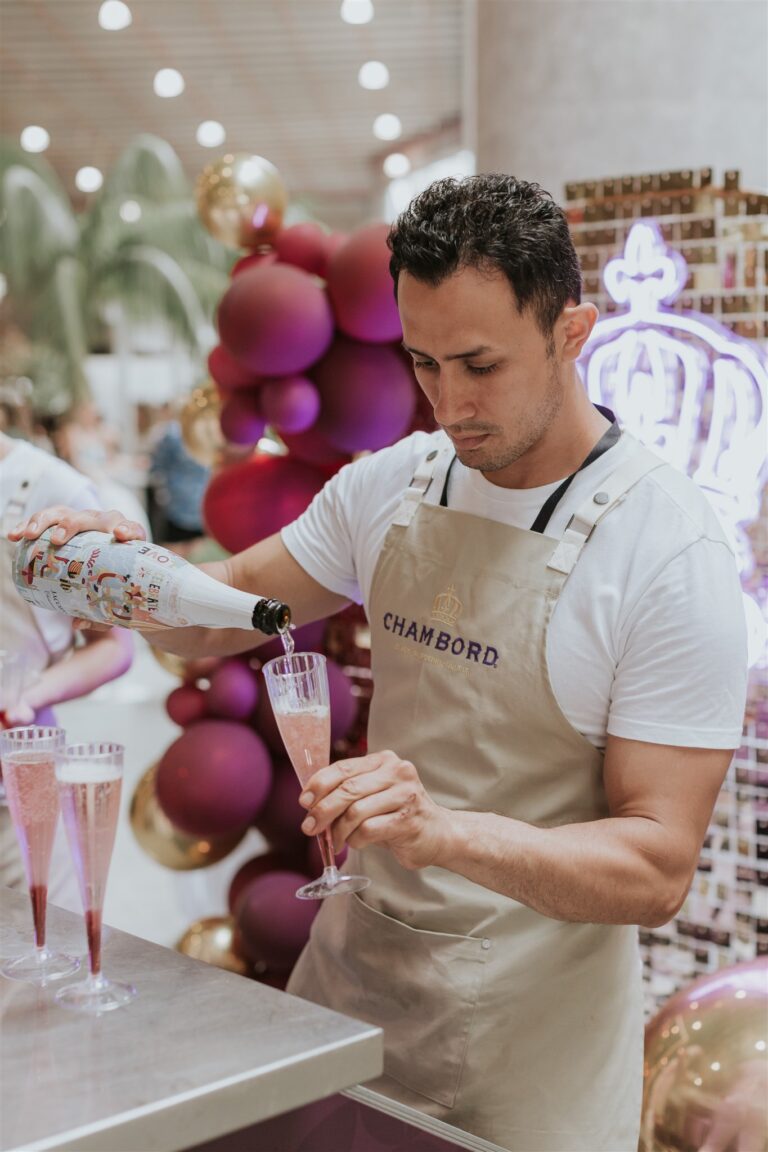 a bartender pouring a drink into a glass