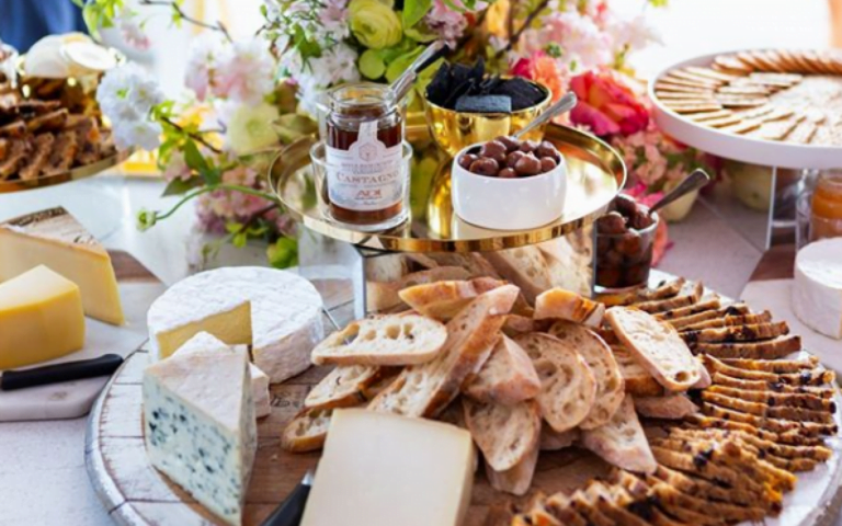 Cheese and crackers on table with gold tray.