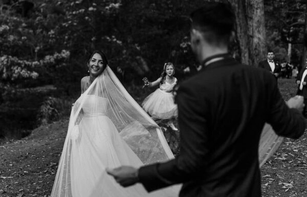 Black & white wedding photograph of a couple spreading the bride's veil