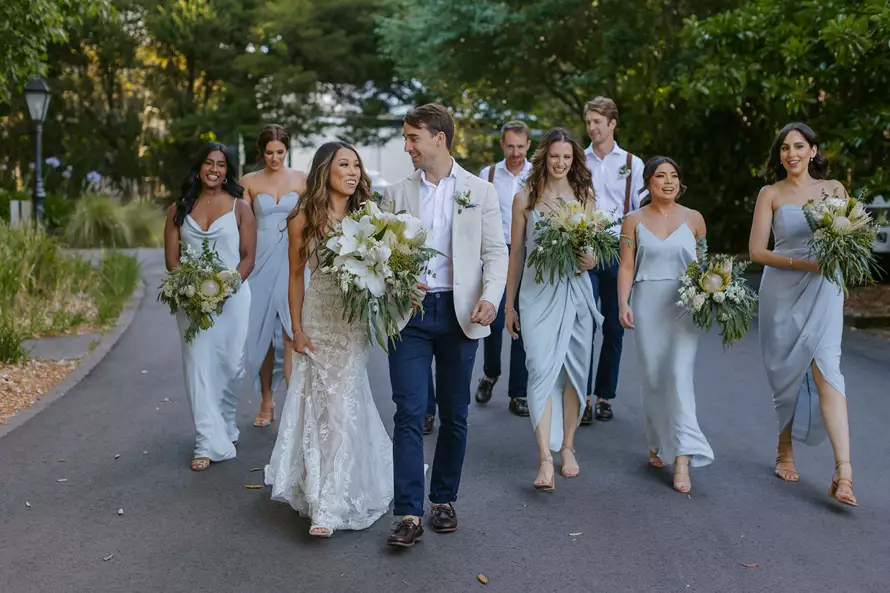 Bridal party holding Lush Flower Co bouquets on a forest path – floral designs by one of the best wedding florists in Sydney.