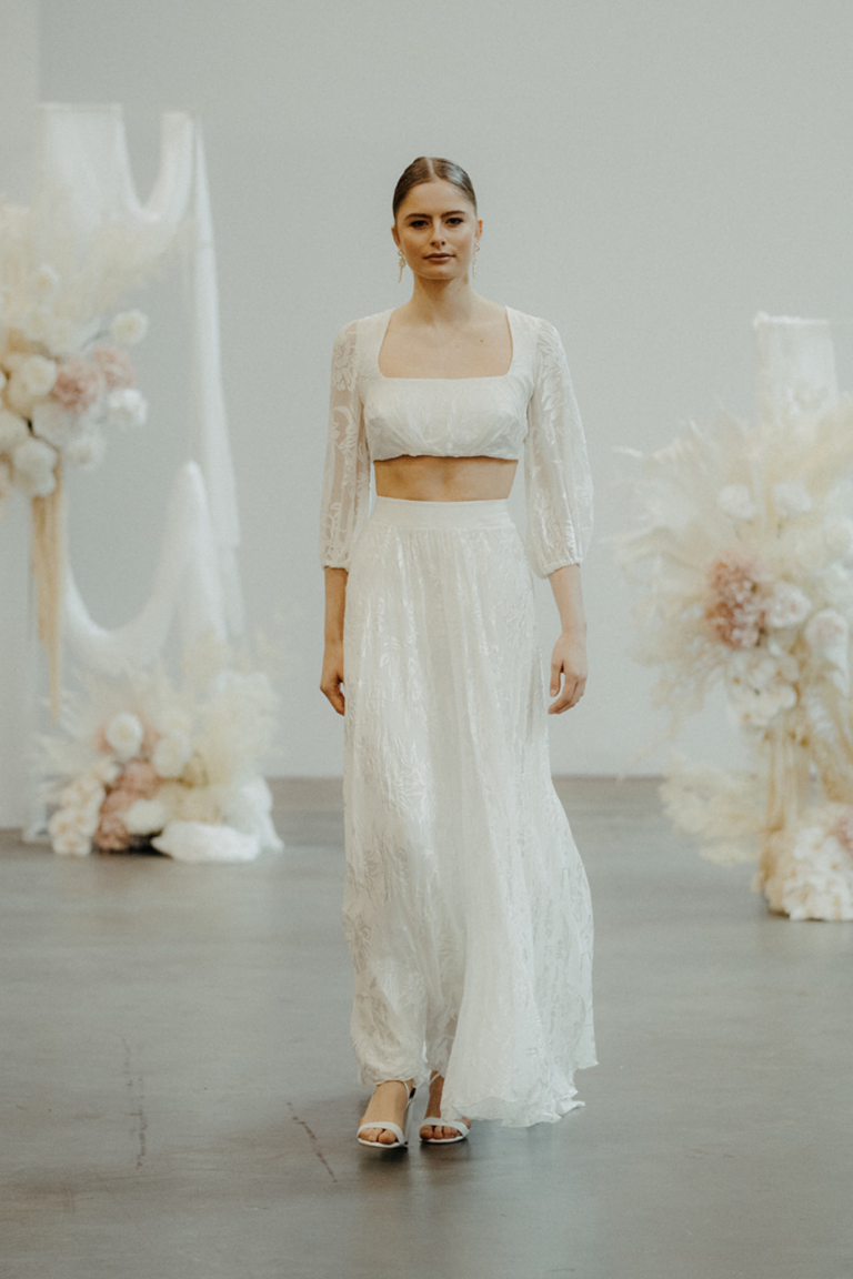 a model in a wedding dress walking down the runway