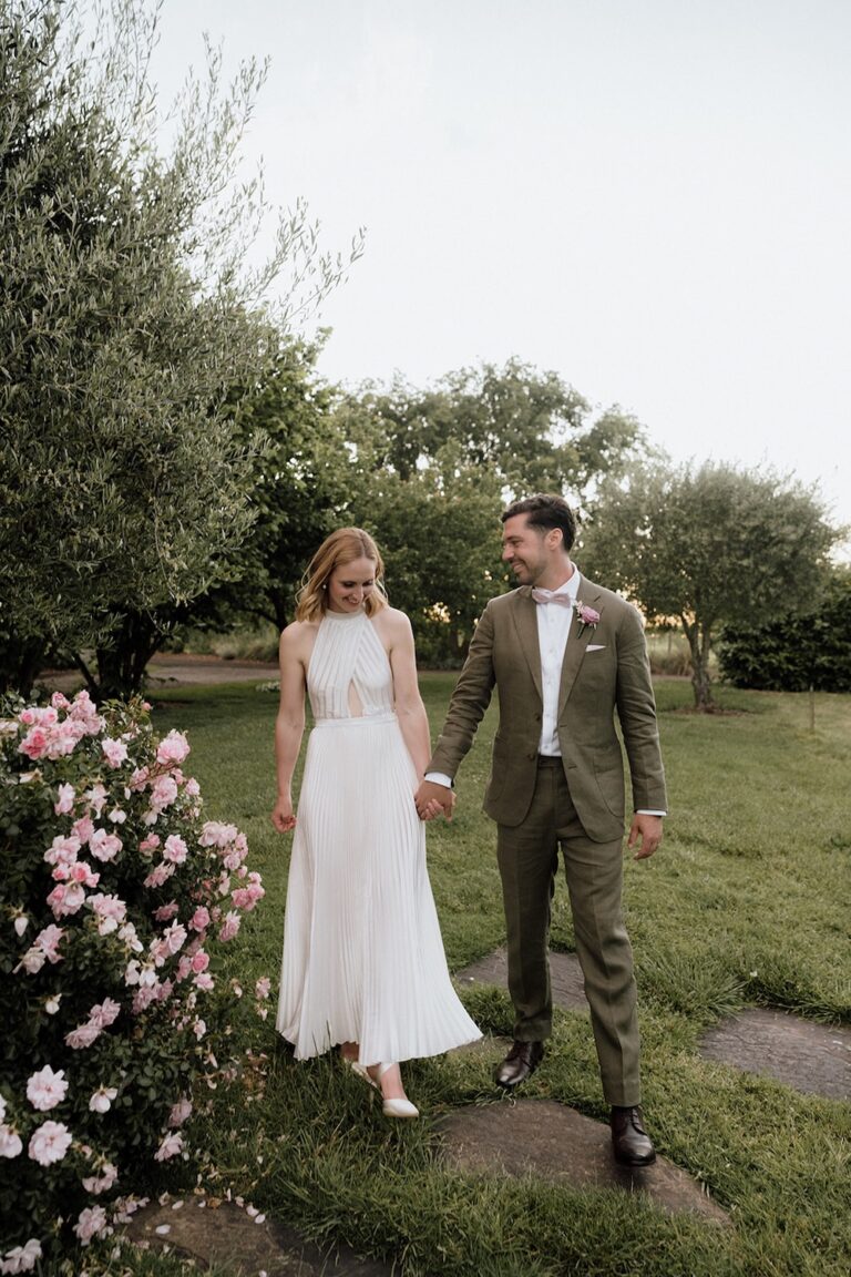 A couple walking through a rose garden.
