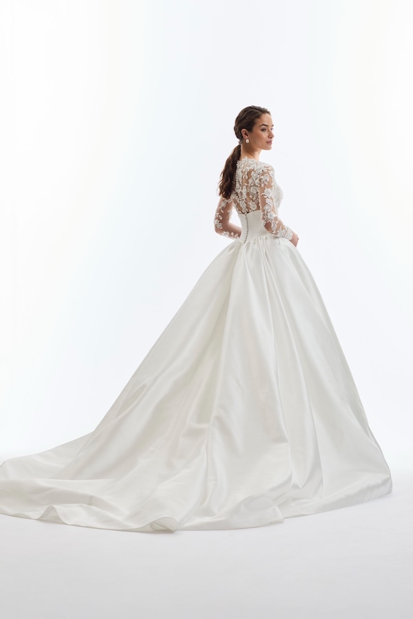 A bride looking back to the camera in a long sleeve wedding dress