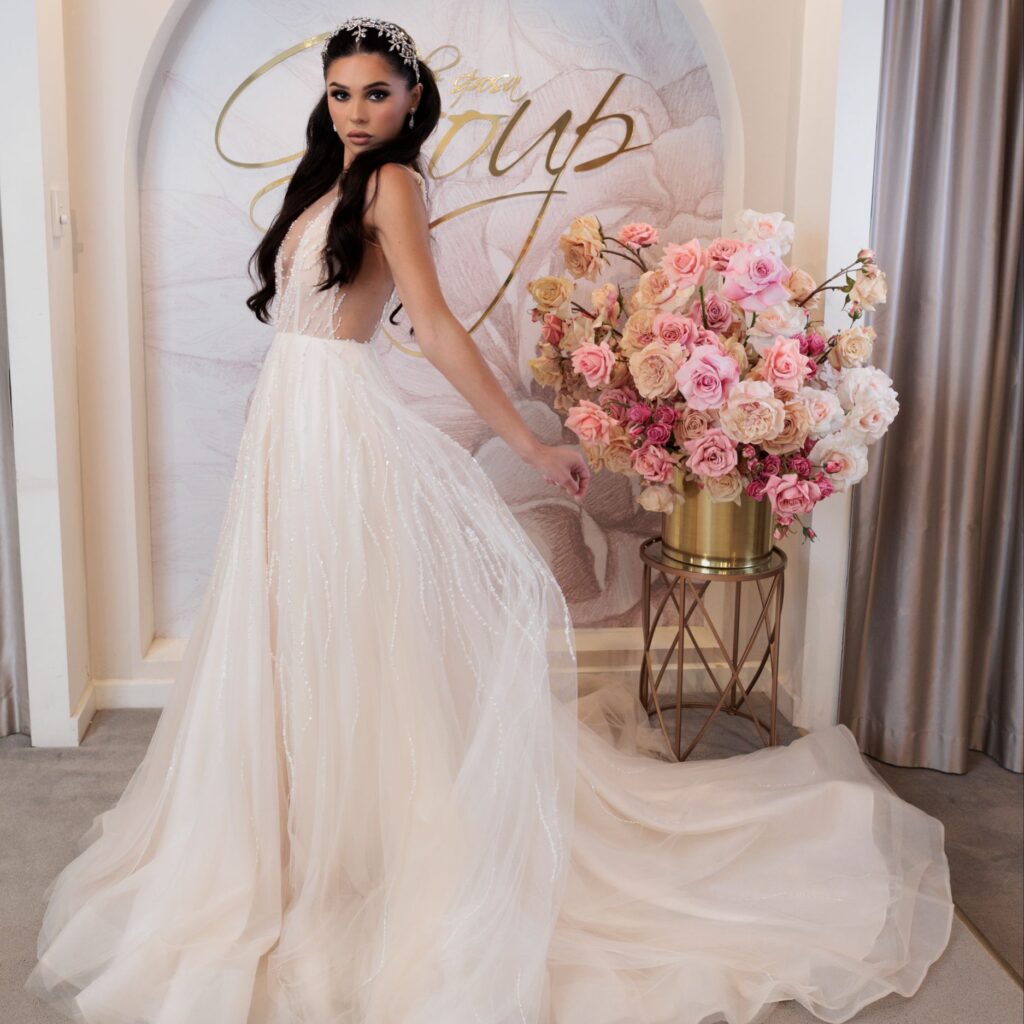 A bride stands inside The Sposa Group boutique, wearing a gown from the best wedding dress shop in Sydney.