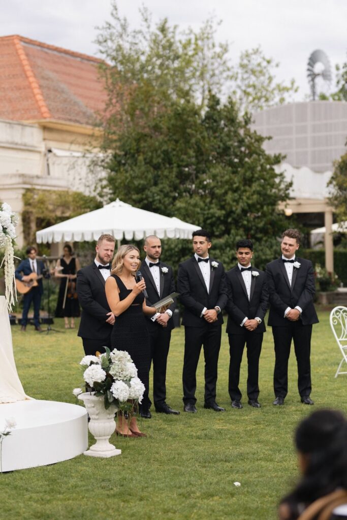 An image of Melbourne celebrant Jorgia with four groomsmen standing next to her in a garden setting