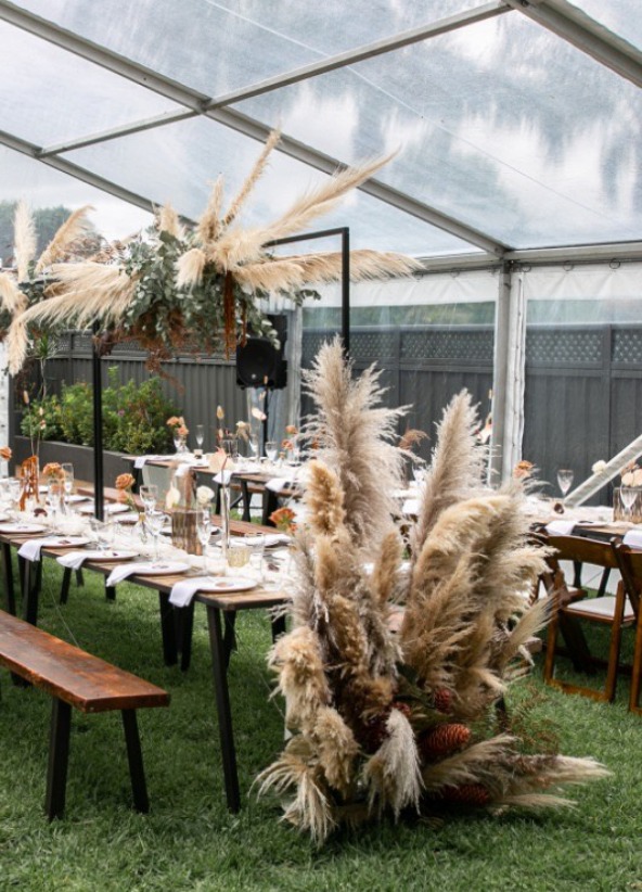 A wedding set up with feathery trees and grass