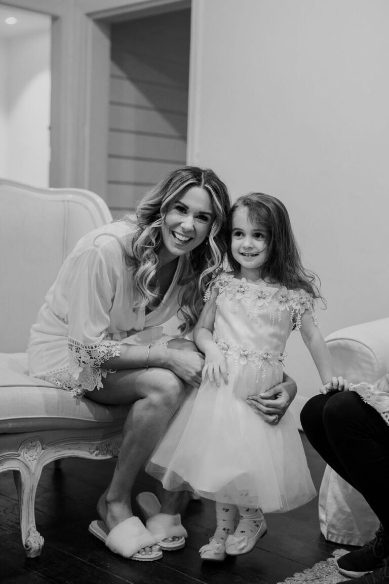 The bride posing for a picture with a little girl.