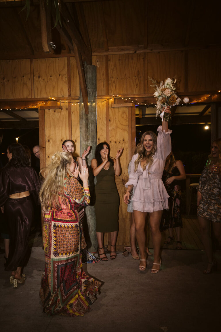 A woman catching the bouquet of flowers.