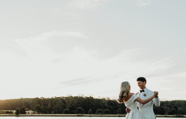 A couple dancing by a lake.
