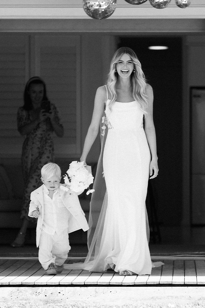 The bride walking together, holding hands with a little boy.