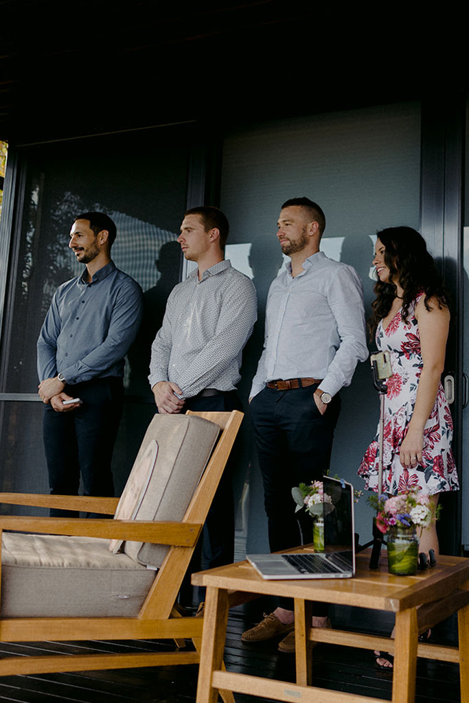 A group of people standing watching the wedding ceremony.