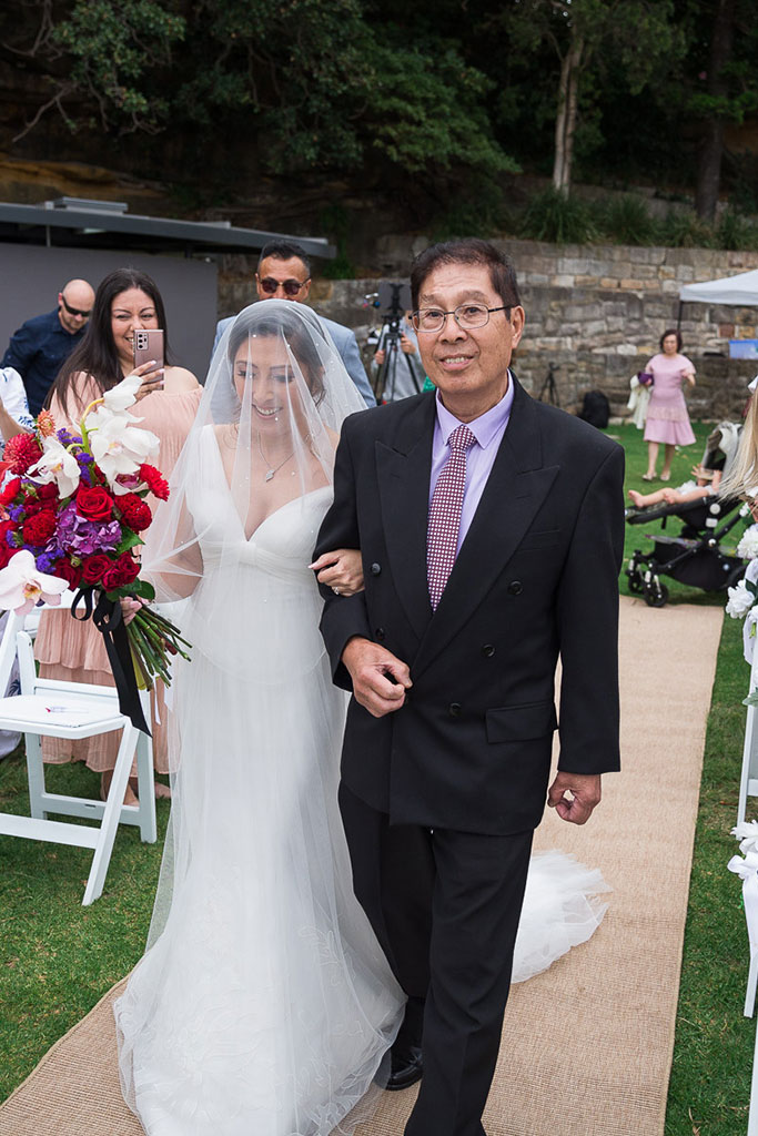 the bride in a wedding dress walking in the aisle with her dad