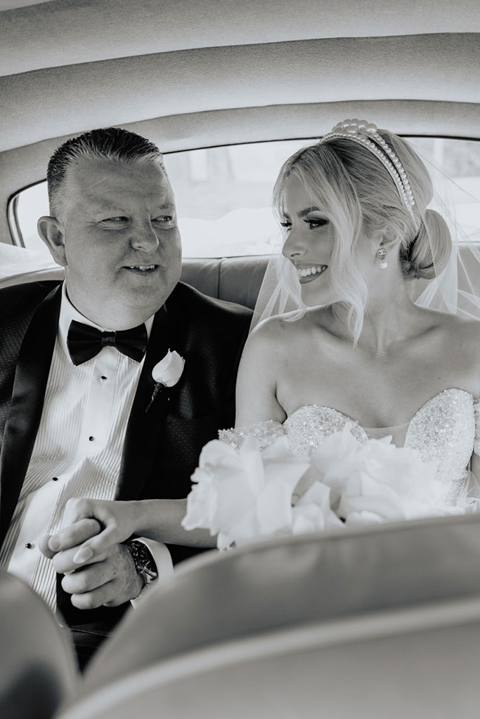 A bride and her father in a car.