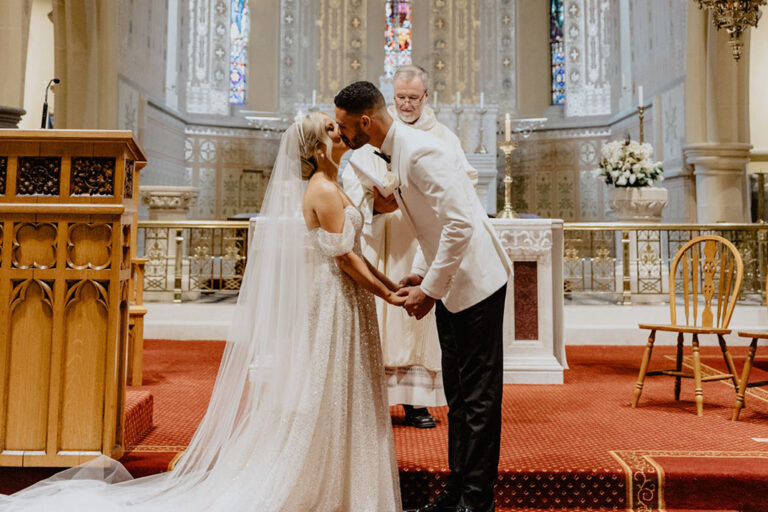 Couple kissing at altar.