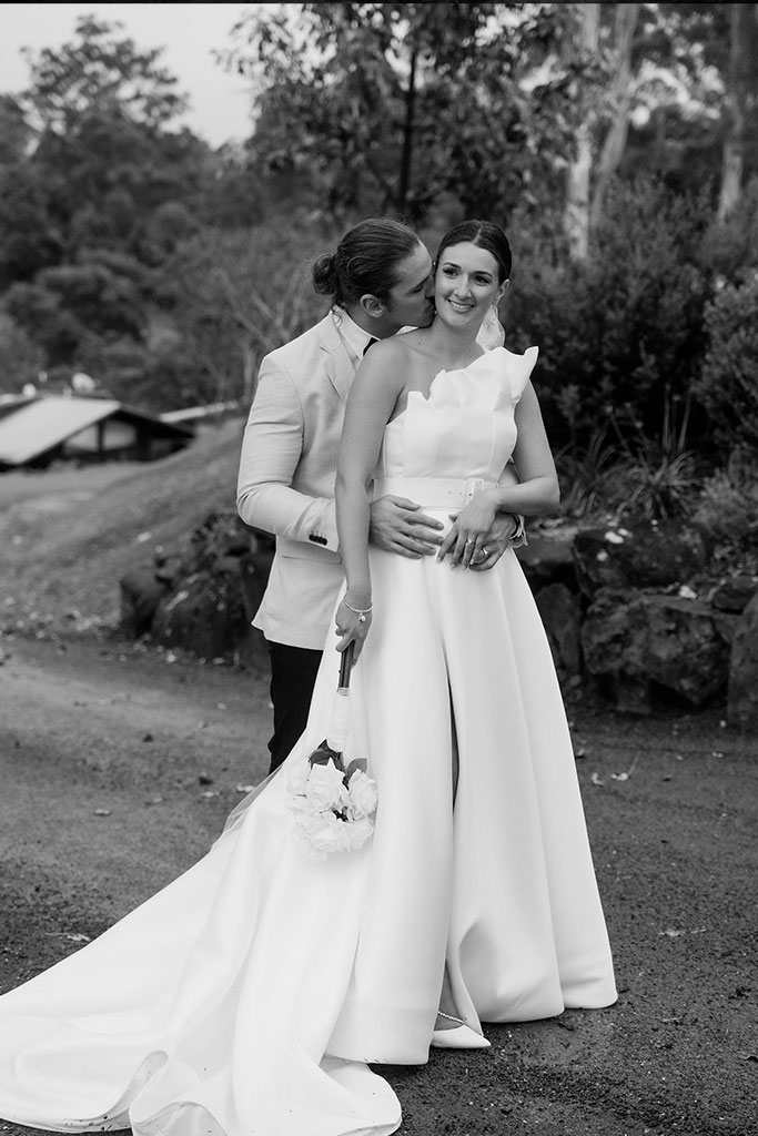 A black and white photo of a bride and groom posing together.