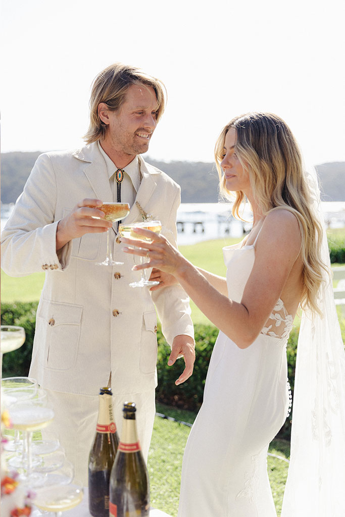 A bride and groom celebrating their wedding with a champagne toast.