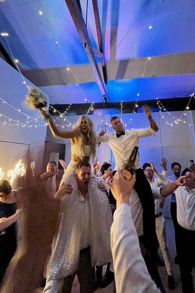 The couple being lifted by two men.