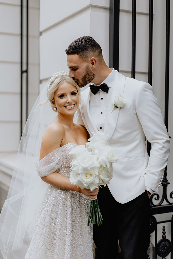 A groom kissing his brides forehead.