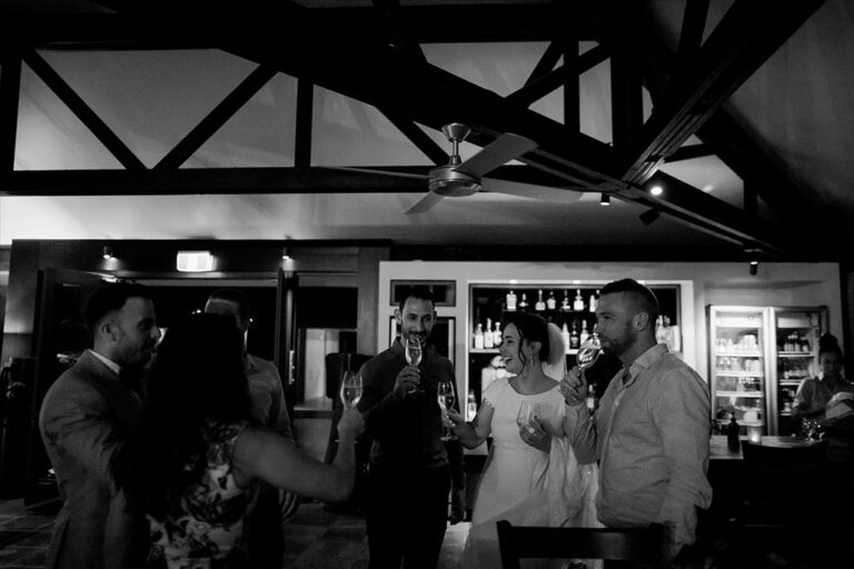 A group of people standing in a room with a bar.