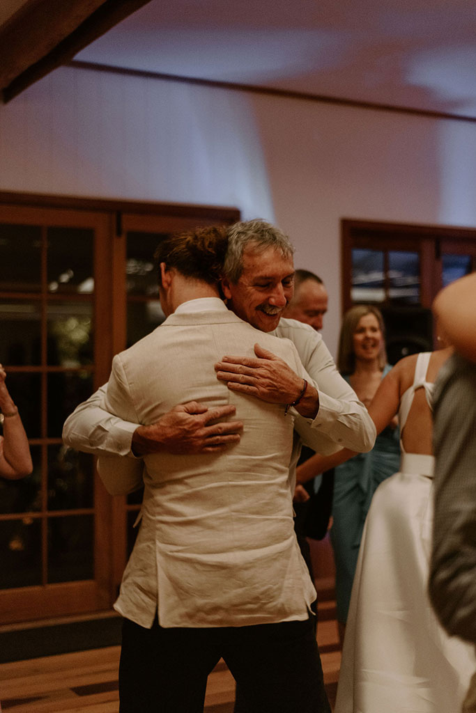 The groom hugging a man.