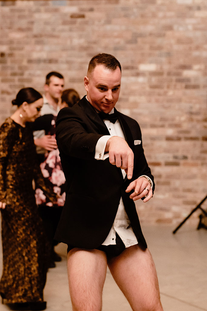 A man dancing in his underwear at a wedding celebration.