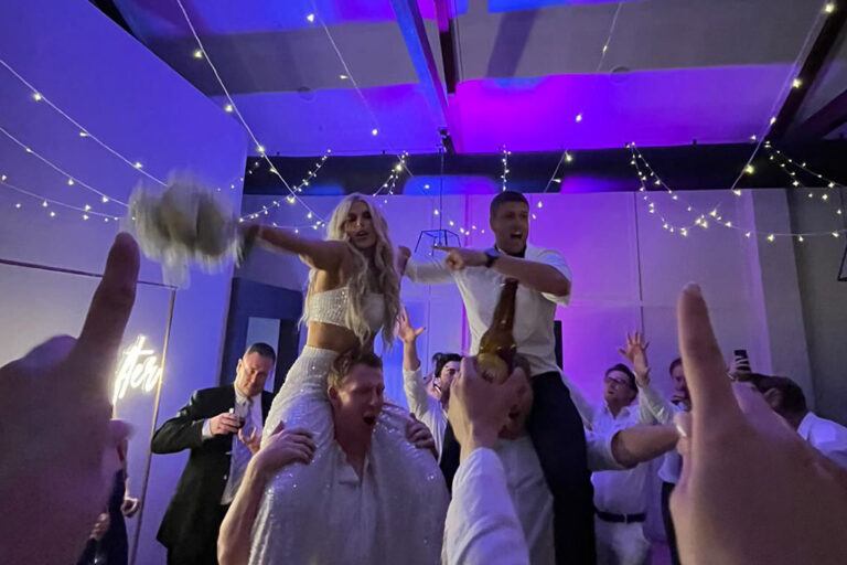 The couple being lifted by two men.