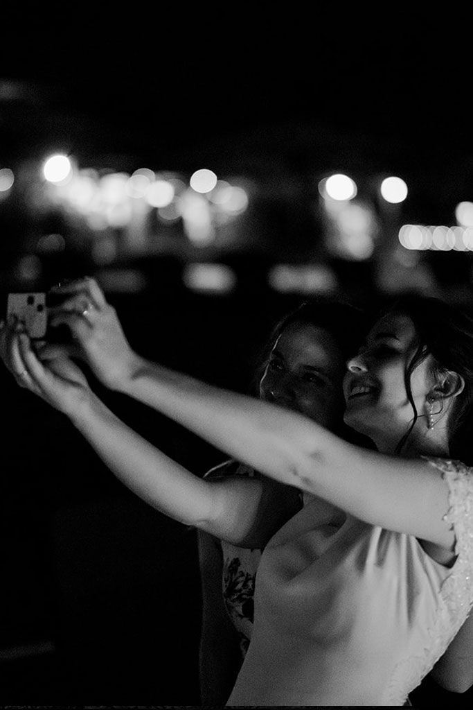 A bride taking a selfie with another woman.