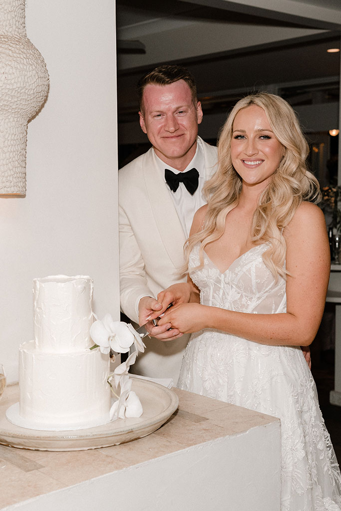 The newlyweds cutting their wedding cake.