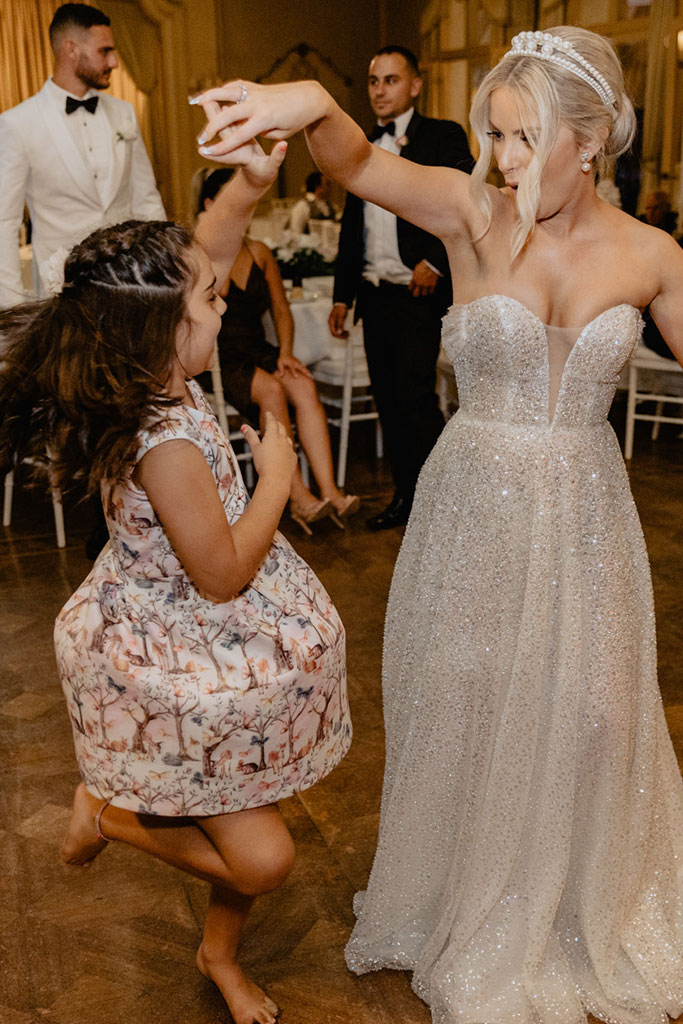 A bride dancing with a little girl.