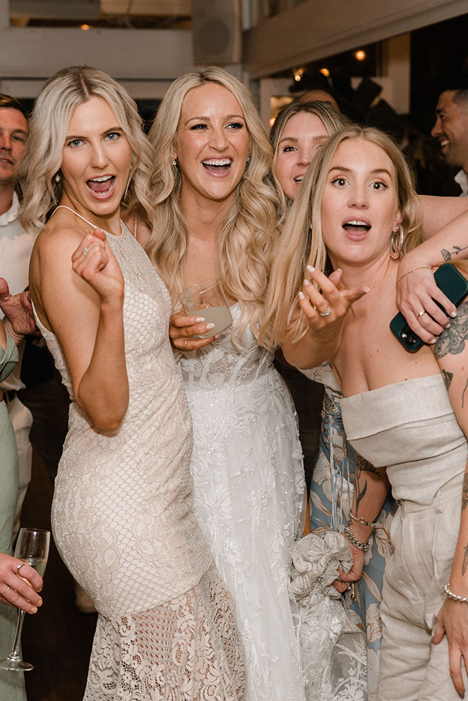A group of with posing for a picture with the bride.