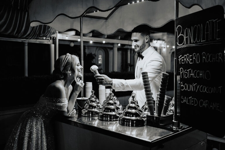 A groom giving his bride an ice cream cone.