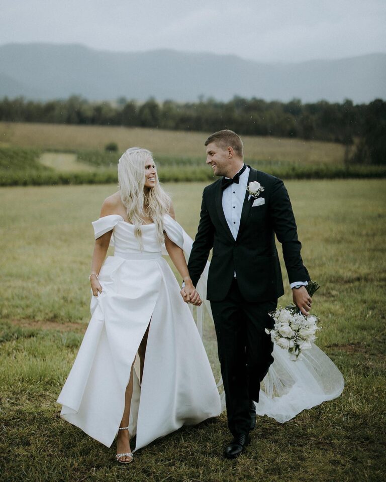 The couple holding hands, walking together.