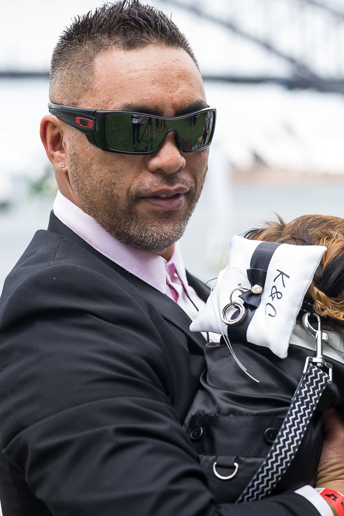 the groom wearing shades while holding a dog