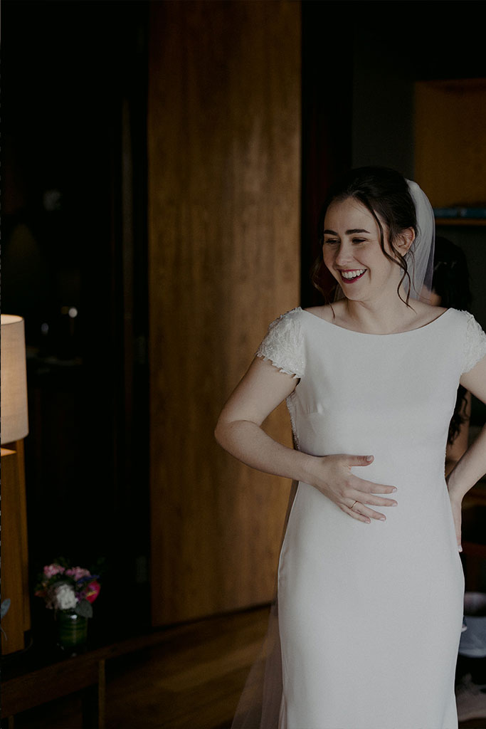 A bride smiling wearing her wedding dress.