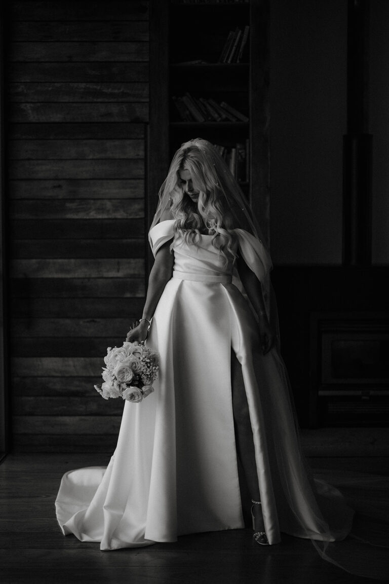 The bride wearing her white wedding dress holding a bouquet of flowers.