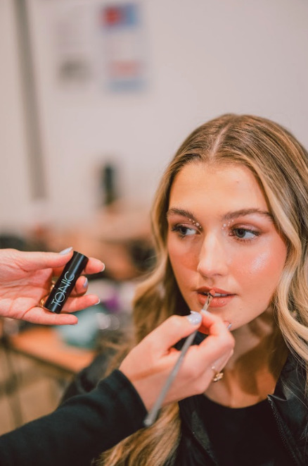 A woman getting her makeup done.