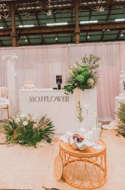 A wedding booth adorned with white and pink flowers.