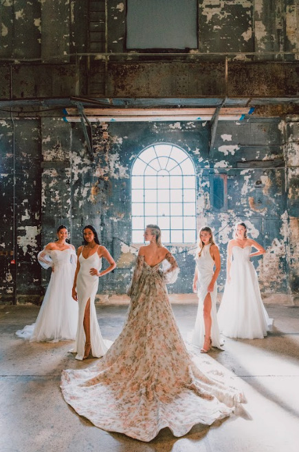 A bride and her bridesmaids posing in an abandoned warehouse.