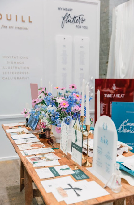 A table with a variety of items including pamphlets and flowers.