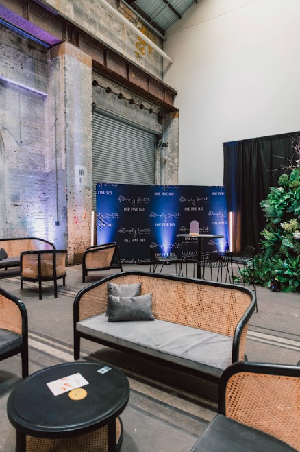 A spacious room with a stage, cozy couches and elegant tables.