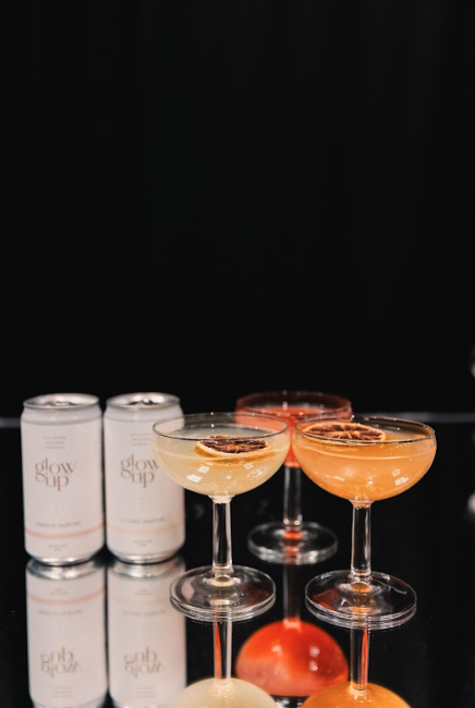 Two canned drinks and three orange cocktails.